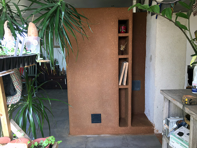 Poêle de masse avec enduit terre et banc chaud et alcoves